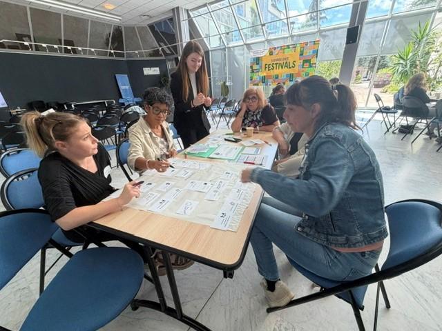 6 personnes autour d'une table en train de travailler en groupe