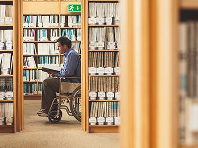 Homme en fauteuil dans une bibliothèque