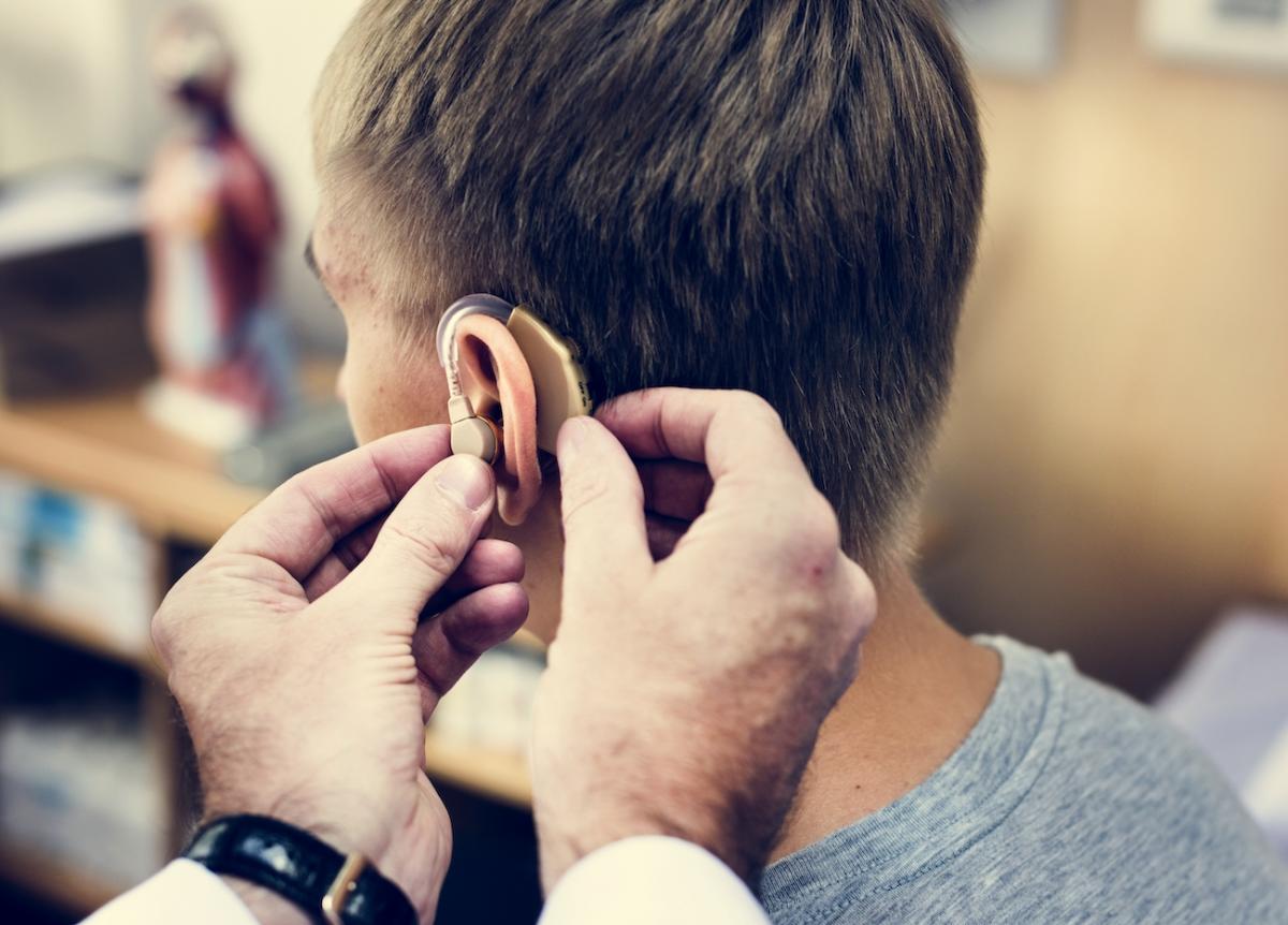 Prothèse auditive en train d'être positionnée sur un patient