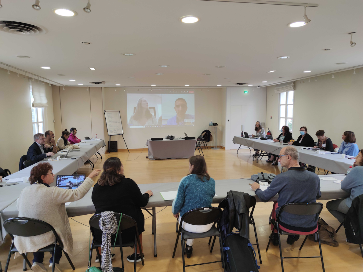 Réunion des participants autour d'une grande salle de réunion