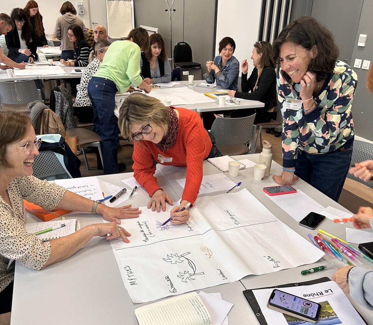 Groupe de travail : plusieurs personnes écrivent sur une grande feuille de paperboard.