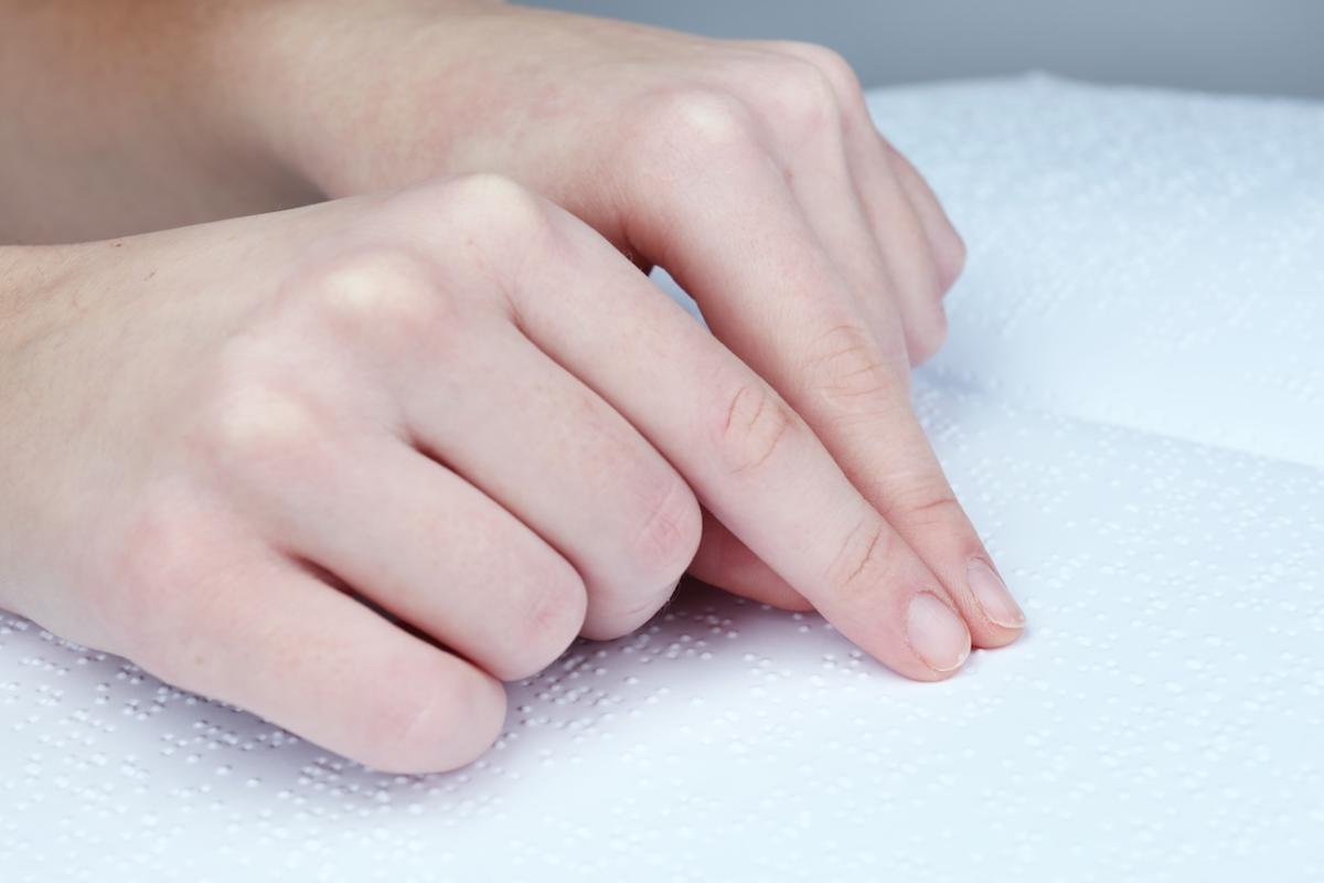 Personne lisant un document en braille (zoom sur ses mains)