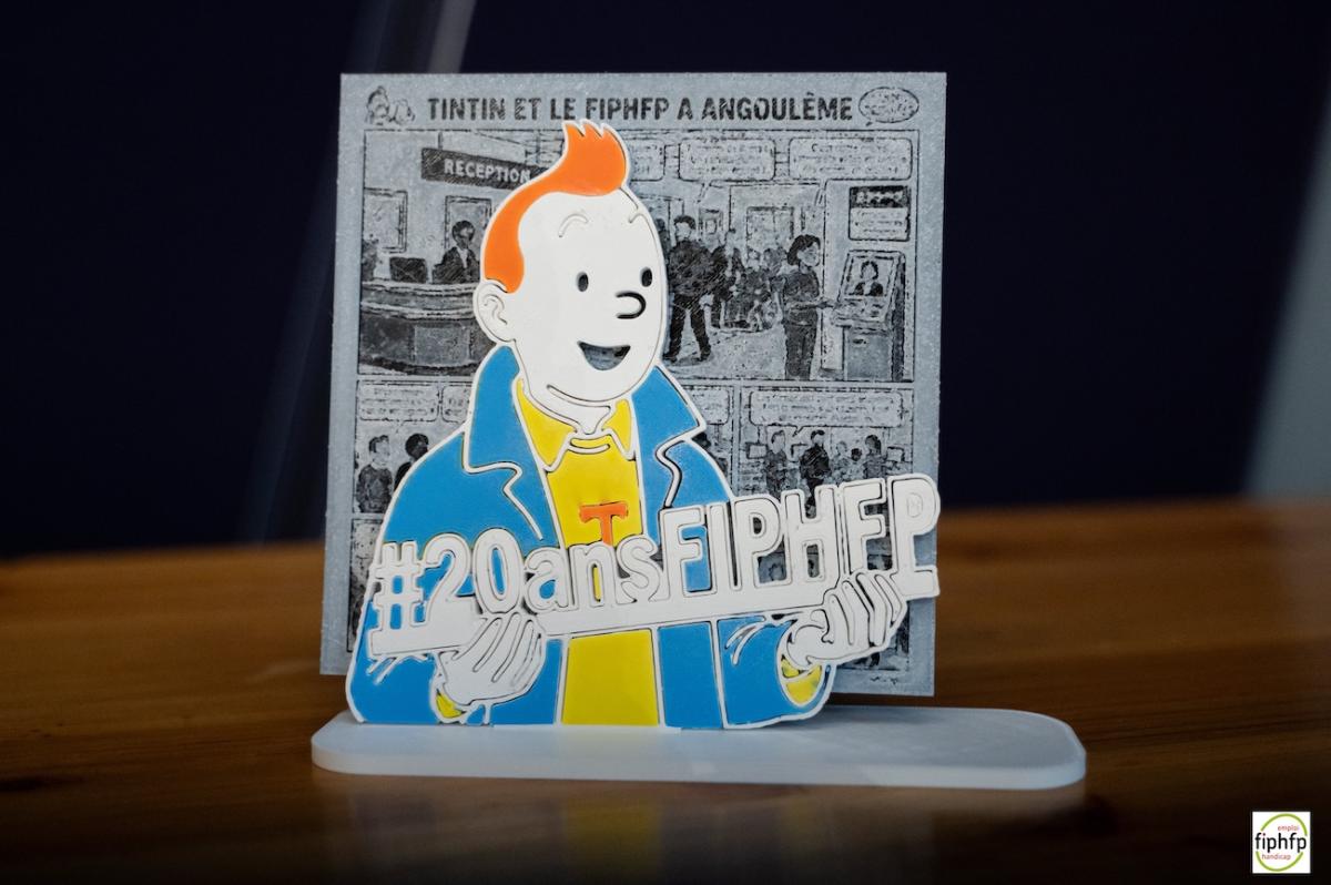 Dessin de tintin tenant une pancarte "20 ans FIPHFP"