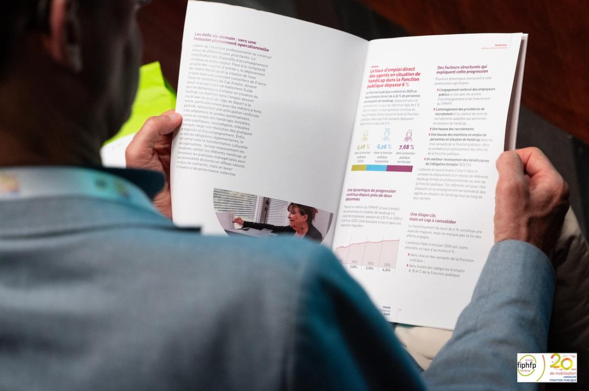 Journaliste lisant le dossier de presse du FIPHFP lors de la conférence de presse du 2 juillet
