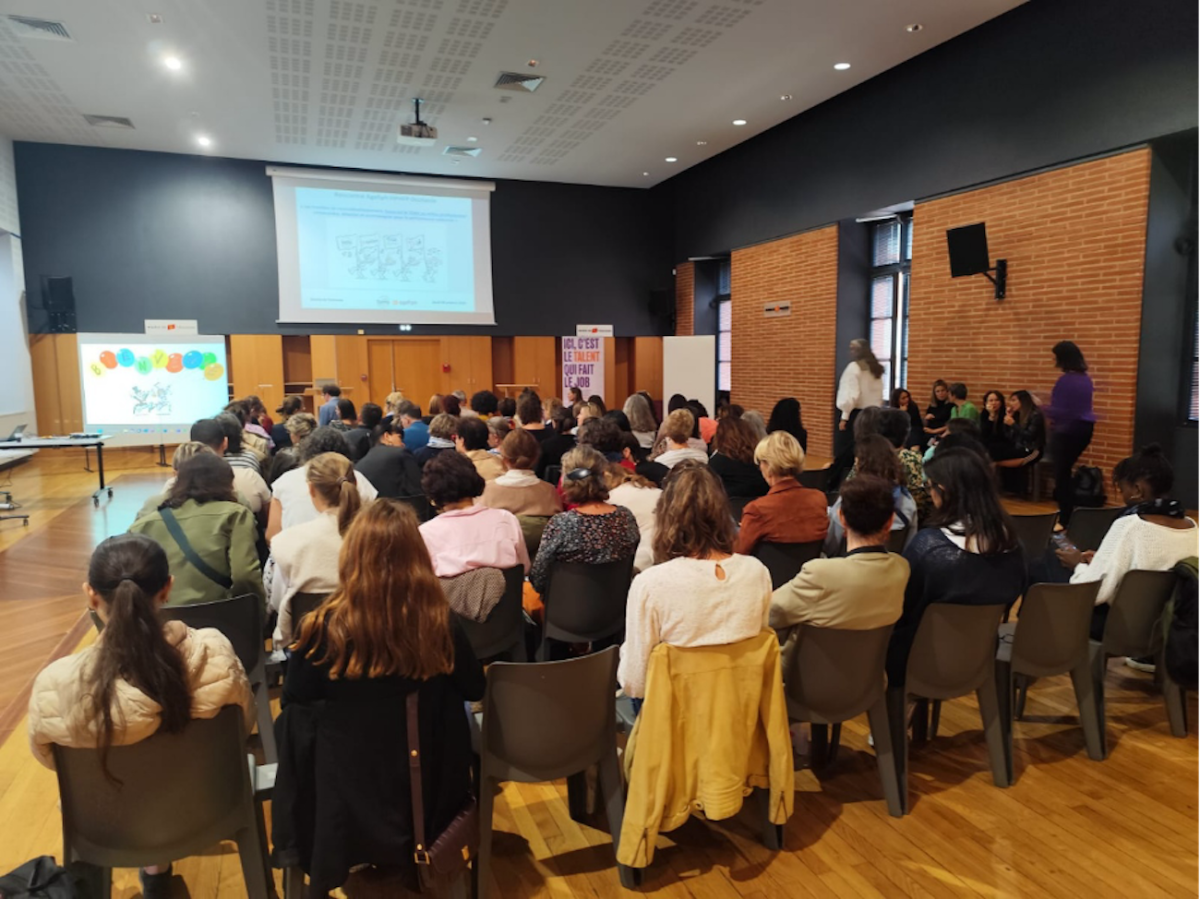Photographie des personnes présentes, de dos, lors de la conférence